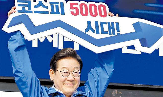 이재명 대통령이 지난달 29일 서울 반포동 고속버스터미널광장에서 한 사전투표 첫째날 유세에서 ‘코스피 5000시대’라고 적힌 피켓을 높이 들고 있다.  뉴스1