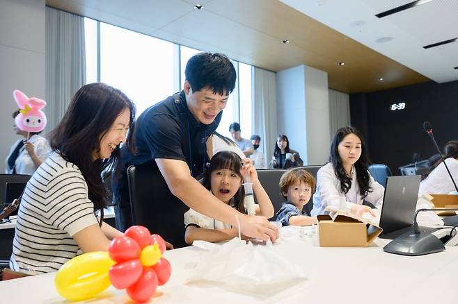 원익IPS 패밀리데이 체험부스에서 한 가족이 썬크림 DIY를 체험중이다.  원익IPS 제공