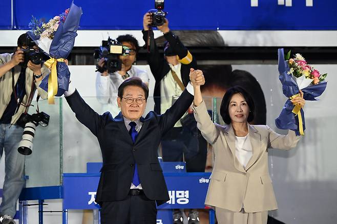 Lee Jae-myung of the liberal Democratic Party, left, and his wife Kim Hye-kyung wave to his supporters at an outdoor stage near the National Assembly in Yeouido, western Seoul, in the early hours of June 4. [KIM SEONG-RYONG]
