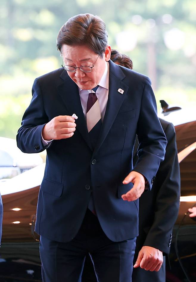 이재명 대통령이 4일 서울 용산 대통령실 청사로 들어서며 이어폰을 정리하고 있다. 연합뉴스