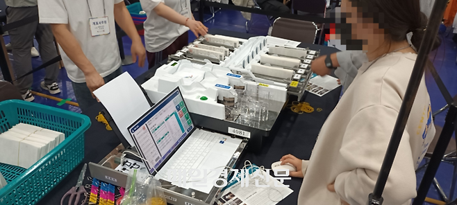 투표지분류기가 투표용지를 스캔한 후 기표된 후보별로 적재함에 100매씩 분류하고 있다. [사진 지혜진 기자]