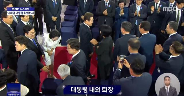 4일 서울 영등포구 국회의사당에서 권성동(두 번째 줄 왼쪽 두 번째) 국민의힘 원내대표가 대통령 취임 선서를 마치고 퇴장하는 이재명 대통령의 배우자 김혜경(권 원내대표 왼쪽) 여사의 인사를 외면하는 모습. [사진 출처 = MBC 보도화면 갈무리]