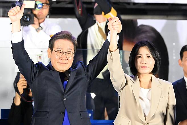 이재명 대통령이 4일 새벽 당선이 확실시되자 서울 여의도 국회 인근에서 더불어민주당 주최 국민개표방송 행사에 참석해 부인 김혜경 여사와 함께 인사하고 있다. [연합]