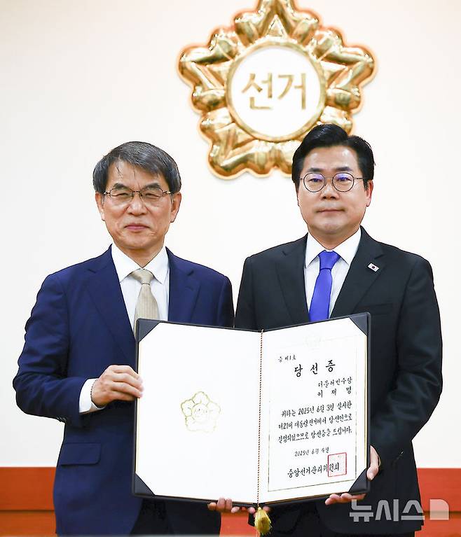 [과천=뉴시스] 김근수 기자 = 노태악 중앙선거관리위원장이 4일 오전 경기 과천시 중앙선거관리위원회 회의실에서 열린 제21대 대통령 당선증 교부식에서 박찬대 더불어민주당 상임 총괄선거대책위원장에게 당선증을 전달하고 기념촬영을 하고 있다. 2025.06.04. ks@newsis.com