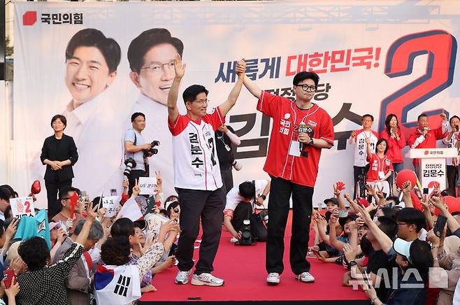 [서울=뉴시스] 권창회 기자 = 한동훈 전 국민의힘 대표가 지난달 26일 서울 도봉구 방학사거리 인근에서 열린 김문수 국민의힘 대선 후보의 집중유세에 지원나와 김 후보와 손을 맞잡고 있다. (공동취재) 2025.05.26. photo@newsis.com