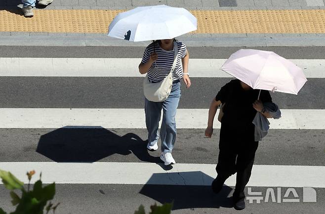 [부산=뉴시스] 하경민 기자 = 무더운 날씨를 보인 4일 부산 동구 부산역 광장 횡단보도에서 시민들이 양산을 쓰고 길을 건너고 있다. 2025.06.04. yulnetphoto@newsis.com