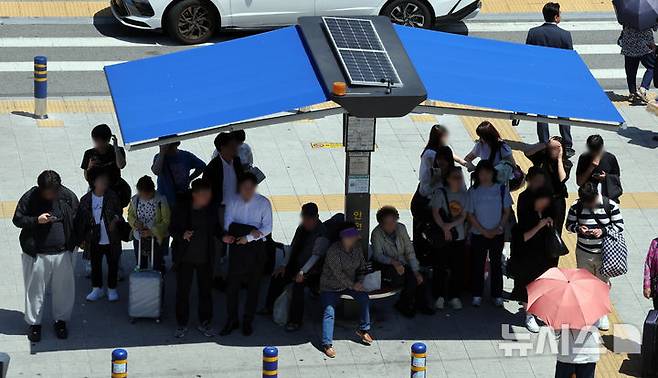 [부산=뉴시스] 하경민 기자 = 무더운 날씨를 보인 4일 부산 동구 부산역 광장 횡단보도 앞에 설치된 그늘막 아래서 시민과 관광객들이 신호를 기다리며 더위를 식히고 있다. 2025.06.04. yulnetphoto@newsis.com