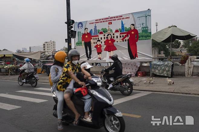 [호치민시티(베트남)=AP/뉴시스]2024년 1월14일 베트남 호치민시티는 출산율 제고를 위해 각 가정이 두 자녀를 갖자는 광고판이 세워져 있다. 베트남이 3일 오랫동안 지속해온 2자녀 제한을 폐지했다. 이는 감소하는 출산율을 되돌리고, 인구 고령화 사회의 부담을 완화하기 위한 것이다. 2025.06.04.