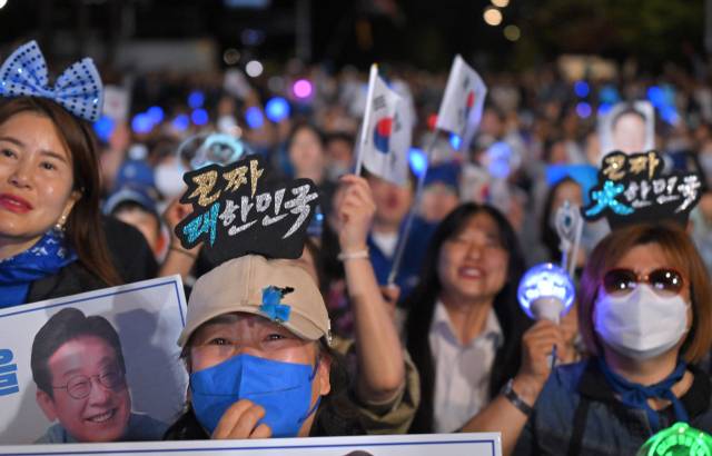 ▲4일 서울 여의도 국회 인근에서 더불어민주당 주최로 열린 제21대 대통령 선거 국민개표방송 행사에 참석한 시민들이 당선이 확실시되는 이재명 대선 후보의 연설을 듣고 있다. ⓒ연합뉴스
