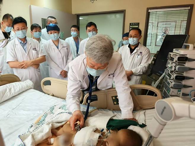 서울아산병원 간이식·간담도외과 이승규 석좌교수가 중국 칭화대 부속 창궁병원에서 생체 간이식 수술을 받은 환아의 상태를 살펴보고 있다. 서울아산병원 제공