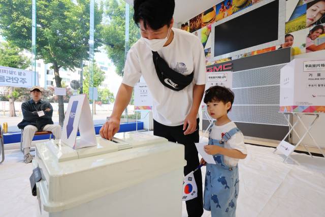 제21대 대통령 선거일인 3일 인천 미추홀구 한 자동차 판매 영업소에 마련된 주안5동 제3투표소에서 한 어린이가 아빠 투표를 지켜보고 있다. 연합뉴스