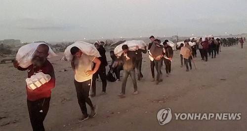 구호품 들고가는 가자 주민들 [로이터=연합뉴스 자료사진]