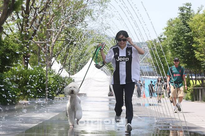 절기상 망종에 초여름 날씨가 이어진 5일 오후 서울 종로구 광화문광장 분수대에서 관광객들이 물놀이를 하며 더위를 식히고 있다. (사진=이영훈 기자)