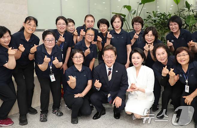 이재명 대통령이 4일 서울 여의도 국회 본청 로텐더홀에서 제21대 대통령 취임 선서를 마친 뒤 청소근로자들과 기념촬영을 하고 있다. 2025.6.4/뉴스1 ⓒ News1 국회사진기자단