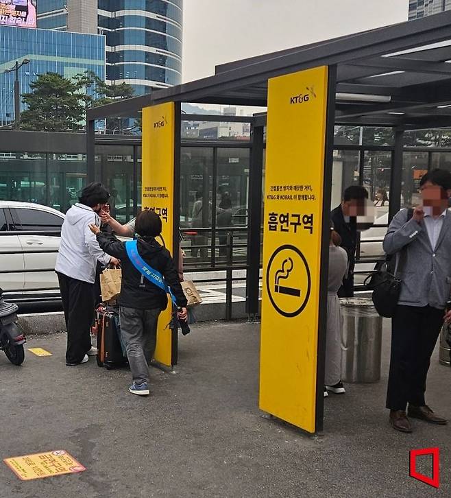 지난 2일 금연지도원이 서울역 광장에 마련된 흡연부스 밖에서 흡연하는 시민에게 부스 안에서 흡연해야 한다고 안내하고 있다. 박승욱 기자