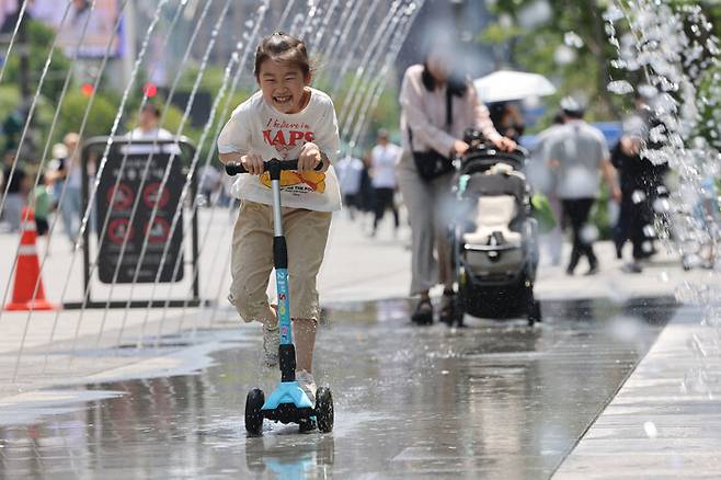초여름 날씨를 보인 5일 서울 종로구 광화문광장에 설치된 분수터널에서 어린이가 더위를 식히고 있다. 연합뉴스