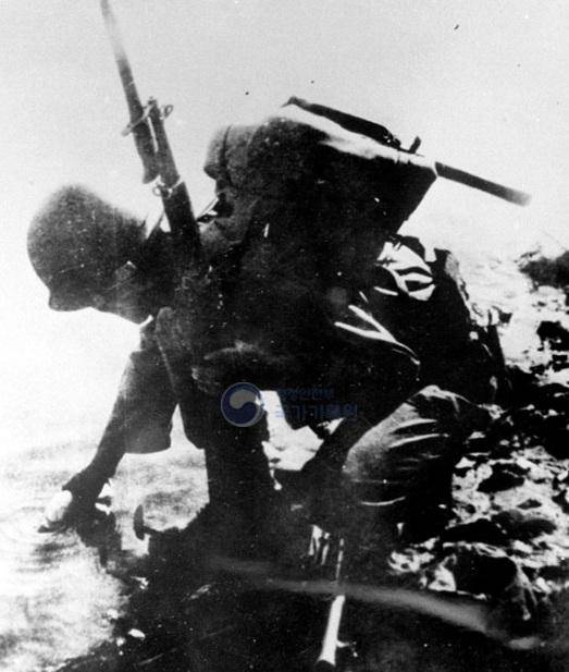 1950년 10월 압록강에 도달한 6사단 7연대 병사가 수통에 물을 담고 있다. 국가기록원