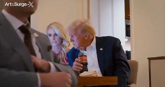 도널드 트럼프 대통령 옆에서 온라인 게시물을 보여주고 있는 나탈리 하프.  Art of the Surge