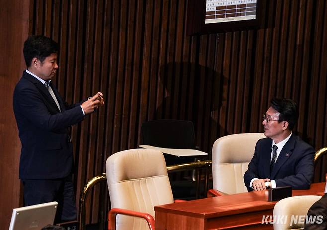 김민석 국무총리 후보자가 5일 서울 여의도 국회 본회의장에서 '3대 특검법과 검사징계법' 등이 통과되는 모습을 배경으로 인증샷을 남기고 있다.