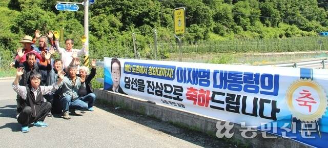 경북 안동시 예안면 도촌리 주민들이 4일 오전 마을 입구에 이재명 대통령 당선 축하 현수막을 설치한 후 “대통령 만세”를 부르고 있다.