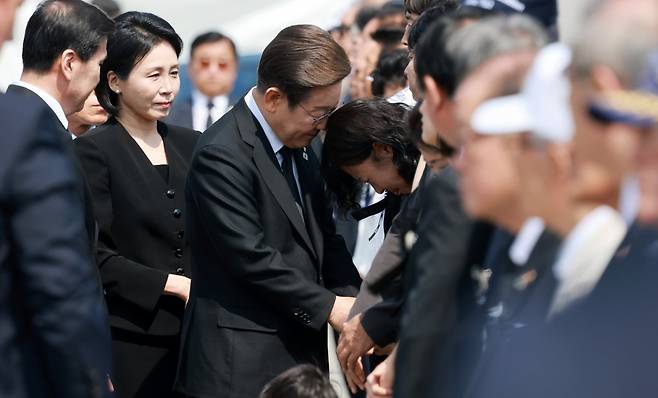 이재명 대통령이 6일 서울 동작구 국립서울현충원에서 열린 제70회 현충일 추념식에 입장하며 한 유족을 위로하고 있다. 뉴시스