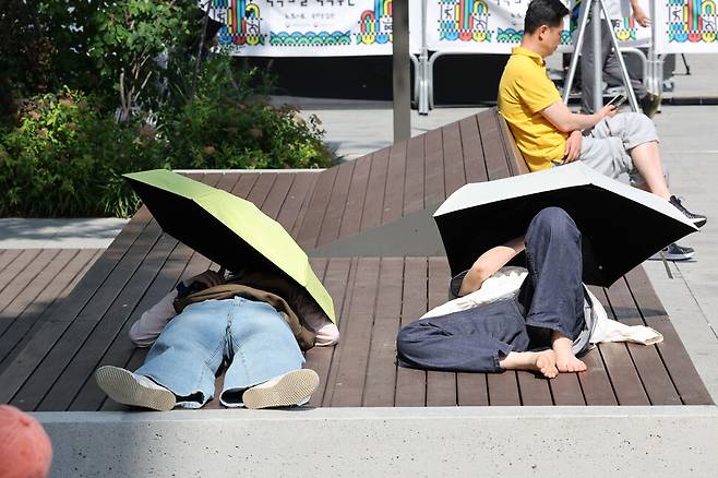 6일 오후 서울 종로구 광화문광장을 찾은 시민들이 우산으로 더위를 피하고 있다. 정용일 선임기자 yongil@hani.co.kr
