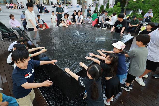 6일 오후 서울 종로구 광화문광장을 찾은 어린이들이 물놀이를 하며 더위를 식히고 있다. 정용일 선임기자 yongil@hani.co.kr