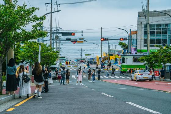 부산 블루라인 파크. 청사포역 철도 건널목은 해운대 해변열차가 지날 때마다 인증 사진을 찍으려는 관광객으로 붐빈다. 평일에는 대부분이 외국인 관광객이다. 지난해에만 120만명의 외국인이 해운대 해변열차와 스카이 캡슐을 탑승했다.