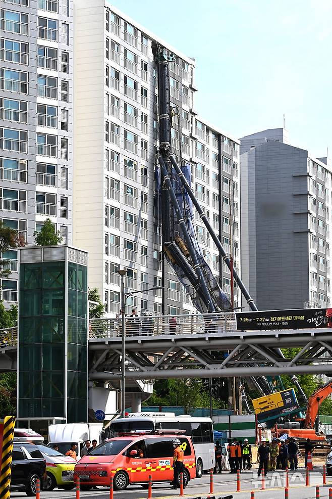 [용인=뉴시스] 김종택 기자 = 6일 경기 용인시 기흥구 서천동 인덕원~동탄 복선전철 공사 현장에서 중장비인 천공기(지반을 뚫는 건설기계)가 15층 높이 아파트 벽면에 기댄 모습으로 쓰러져 있다. 2025.06.06. jtk@newsis.com