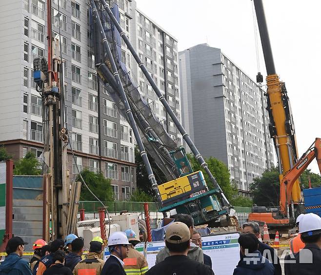 [용인=뉴시스] 김종택 기자 = 6일 경기 용인시 기흥구 서천동 인덕원~동탄 복선전철 공사 현장에서 중장비인 천공기(지반을 뚫는 건설기계)가 15층 높이 아파트 벽면에 기댄 모습으로 쓰러져 있다. 2025.06.06. jtk@newsis.com
