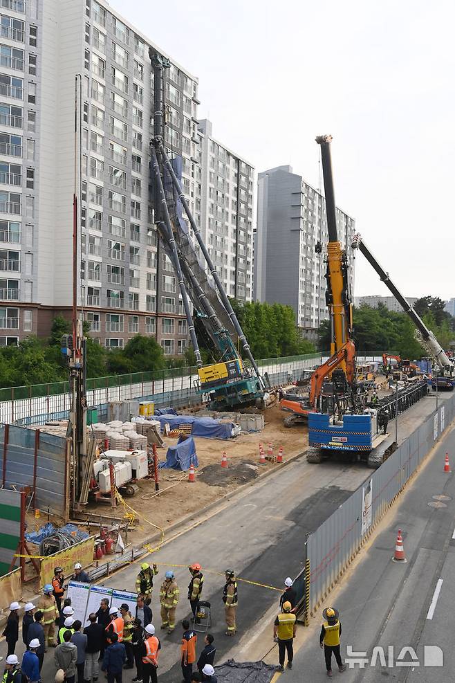 [용인=뉴시스] 김종택 기자 = 6일 경기 용인시 기흥구 서천동 인덕원~동탄 복선전철 공사 현장에서 중장비인 천공기(지반을 뚫는 건설기계)가 15층 높이 아파트 벽면에 기댄 모습으로 쓰러져 있다. 2025.06.06. jtk@newsis.com