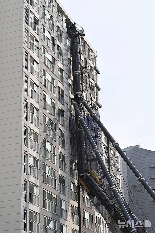 [용인=뉴시스] 김종택 기자 = 6일 경기 용인시 기흥구 서천동 인덕원~동탄 복선전철 공사 현장에서 중장비인 천공기(지반을 뚫는 건설기계)가 15층 높이 아파트 벽면에 기댄 모습으로 쓰러져 있다. 2025.06.06. jtk@newsis.com