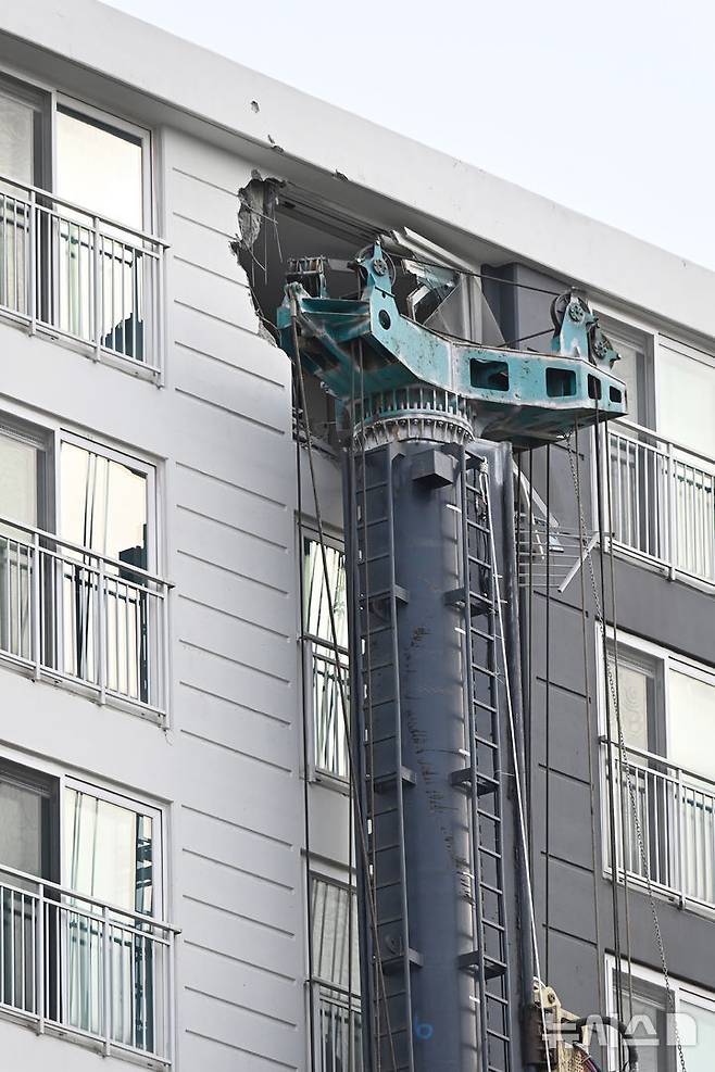 [용인=뉴시스] 김종택 기자 = 6일 경기 용인시 기흥구 서천동 인덕원~동탄 복선전철 공사 현장에서 중장비인 천공기(지반을 뚫는 건설기계)가 15층 높이 아파트로 쓰러져 벽면 일부와 베란다 창문 등이 파손돼 있다. 2025.06.06. jtk@newsis.com