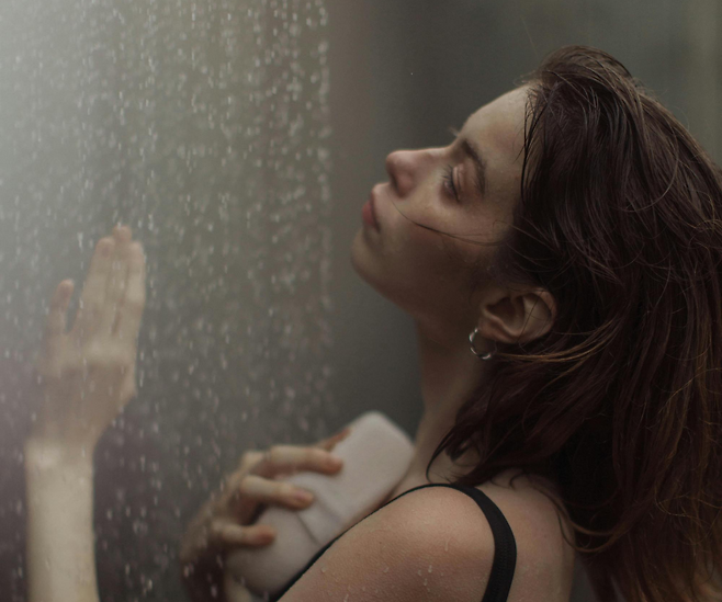 샤워기 물을 맞고 있는 여성