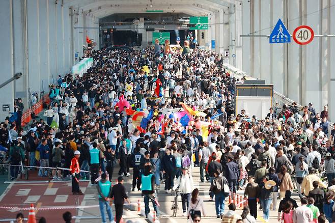지난 5월 4일 오후 서울 서초구 잠수교에서 열린 ‘2025 차 없는 잠수교 뚜벅뚜벅 축제’에서 가면 퍼레이드에 참여한 시민들이 행진하고 있다. (사진=연합뉴스)