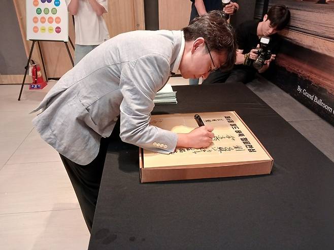 목진석 9단이 대회 개막에 앞서 기념 바둑판에 사인을 남기고 있다.(신안에서 MHN 엄민용 선임기자)