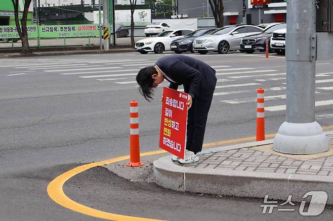 국민의힘 조지연 의원(경산시)이 지난 6일 경산시내 한 도로에서 '죄송합니다. 깊이 반성하고 변화하겠습니다'란 문구가 적힌 피켓을 들고 90도로 고개숙여 인사하고 있다. (조지연 의원 페이스북 갈무리)/뉴스1