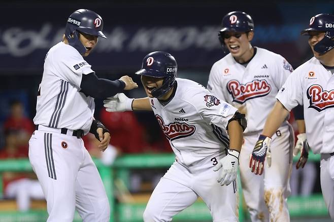 임종성(가운데)이 득점 후 선수들의 축하를 받고 있다. 사진 | 두산 베어스