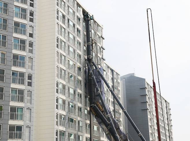 지난 6일 경기도 용인시 기흥구 서천동 아파트에 천공기가 건물에 기댄 모습으로 쓰러져 있다. 연합뉴스