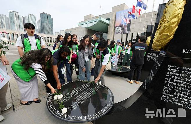 [서울=뉴시스] 홍효식 기자 = 7일 서울 용산구 전쟁기념관 평화의 광장에서 유엔참전국 후손 교류캠프 참가자들이 유엔참전용사들의 숭고한 희생을 기리며 참전기념비에 헌화하고 있다. 2025.06.07. yesphoto@newsis.com