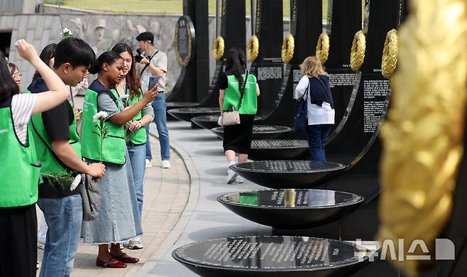 [서울=뉴시스] 홍효식 기자 = 7일 서울 용산구 전쟁기념관 평화의 광장에서 유엔참전국 후손 교류캠프 참가자들이 유엔참전용사들의 숭고한 희생을 기리며 참전기념비에 헌화하고 있다. 2025.06.07. yesphoto@newsis.com