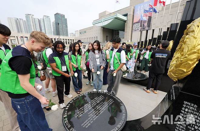 [서울=뉴시스] 홍효식 기자 = 7일 서울 용산구 전쟁기념관 평화의 광장에서 유엔참전국 후손 교류캠프 참가자들이 유엔참전용사들의 숭고한 희생을 기리며 참전기념비에 헌화하고 있다. 2025.06.07. yesphoto@newsis.com