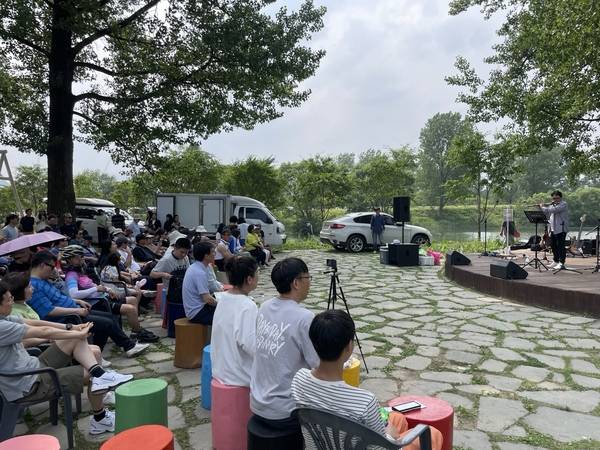 지난 7일 가평 자라섬꽃페스타를 찾은 시민들이 지역예술가의 대금 공연을 감상하고 있다. 2025.6.7 가평/김민수기자 kms@kyeongin.com