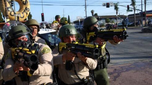 미국 로스앤젤레스에서 비합법 이민자 단속에 나선 이민세관단속국 요원 등이 주민들의 반대 시위에 직면하자, 시위대에게 가스총을 겨누고 있다. 로이터 연합뉴스