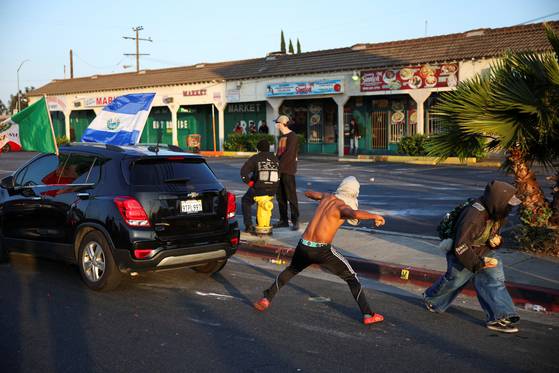 미국 캘리포니아주 로스앤젤레스 카운티 파라마운트에서 이민 및 세관 집행국(ICE)의 체포에 항의하는 시위대가 경찰을 향해 돌을 던지고 있다. 로이터=연합뉴스