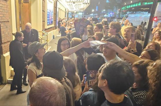 7일(현지시간) 미국 뉴욕 브로드웨이 벨라스코 극장 앞에서 한국 창작 뮤지컬 ‘어쩌면 해피 엔딩’(미국 작품명 ‘Maybe Happy Ending’)의 여성 ‘헬퍼봇’ 클레어 역을 맡은 중국계 미국 배우 헬렌 셴이 팬에게 자신의 사인이 담긴 소책자를 건네고 있다. 뉴욕=김형구 특파원