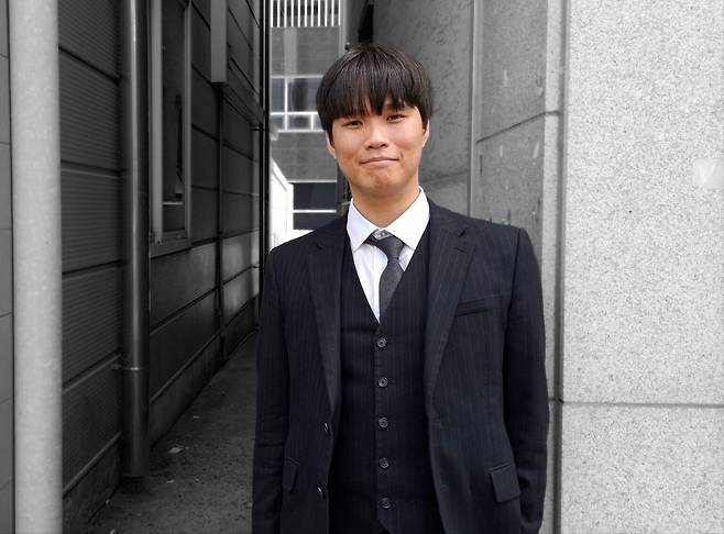 Kim Yong-min, now 26, poses for a photo before an interview with The Korea Herald. (Shin Ji-hye/The Korea Herald)