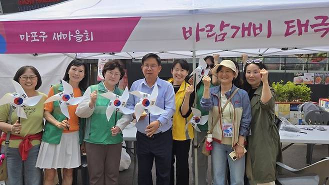 [서울=뉴시스] 박강수 마포구청장이 한반도 대축제에서 태극기 바람개비를 들고 기념촬영을 하고 있다. 2025.06.08. (사진=마포구 제공) *재판매 및 DB 금지