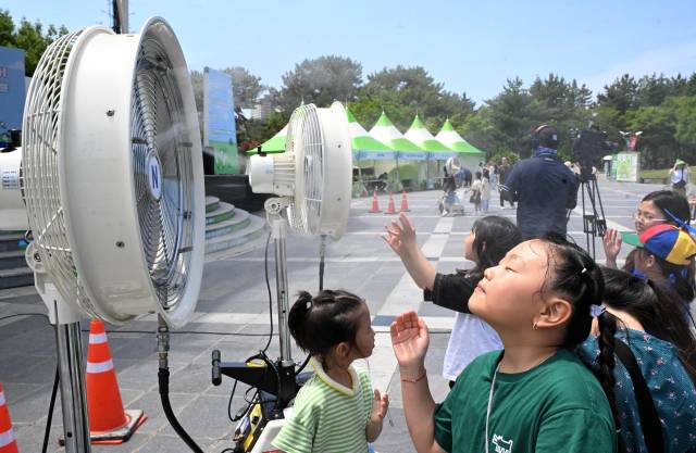 지난 7일 창원용지문화공원에서 열린 제17회 창원그린엑스포에서 아이들이 미스트 선풍기 앞에서 더위를 식히고 있다./성승건 기자/