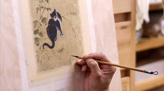 화훼영모화첩 중 '추일한묘'에 대한 결손부 메움 후 색맞춤 과정을 진행 중인 모습.<대구간송미술관 제공>